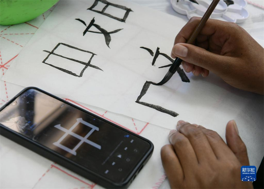 4月18日，肯尼亞學(xué)生在內(nèi)羅畢大學(xué)孔子學(xué)院舉辦的活動上寫毛筆字?？夏醽唭?nèi)羅畢大學(xué)孔子學(xué)院18日舉辦“中文，增進文明對話”主題活動，慶祝即將到來的第14個聯(lián)合國中文日?？夏醽唽W(xué)生參與互動，進行書法、剪紙、唱中文歌等活動。新華社記者 韓旭 攝