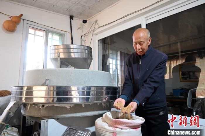 李家莊村民谷文朝重拾父輩的手藝，做起石磨面粉的營生。　翟羽佳 攝