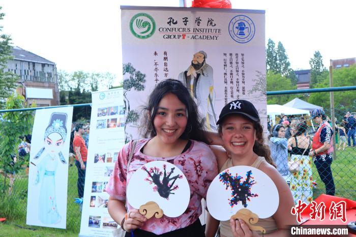 孩子們展示自己的吹墨畫(huà)團(tuán)扇作品?！◆斻肟鬃訉W(xué)院供圖