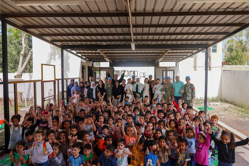 當?shù)貢r間5月30日，黎巴嫩南部庫雷拉公立小學，“六一”國際兒童節(jié)前夕，中國第21批赴黎維和多功能工兵分隊官兵看望慰問學校師生，并開展文化交流活動，圖為我維和官兵同師生合影。李竹林攝