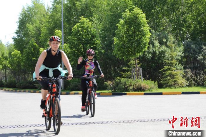 亞信副秘書長(zhǎng)遲方(右一)與聯(lián)合國駐哈協(xié)調(diào)員在騎行活動(dòng)中?！喰琶貢幑﹫D