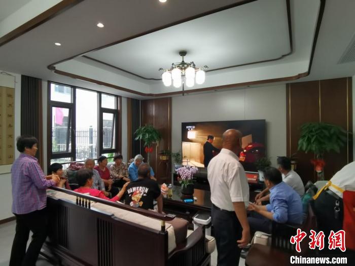 親友們集中在費(fèi)俊龍家中觀看返程的視頻?！＄娚?攝