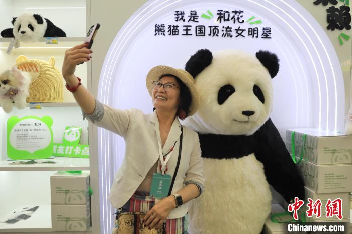 美國華視總裁楊蓮花與大熊貓文創(chuàng)產(chǎn)品合影。　王磊 攝