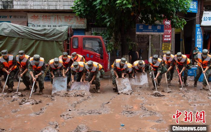 7月4日，萬州區(qū)五橋街道，武警官兵清理街道上的淤泥?！∪矫宪?攝