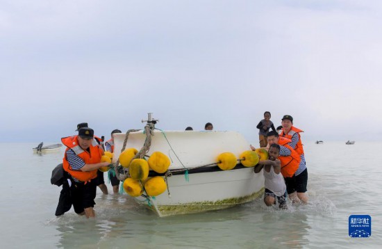7月21日，中國海軍“和平方舟”號醫(yī)院船醫(yī)護人員涉水登島，前往基里巴斯一診療點。新華社記者 黎云 攝