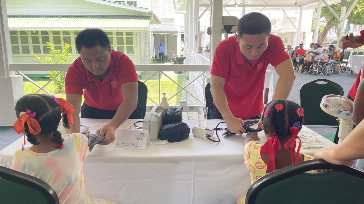 醫(yī)療隊(duì)員為福利院兒童進(jìn)行檢查。第18期援圭亞那醫(yī)療隊(duì)供圖
