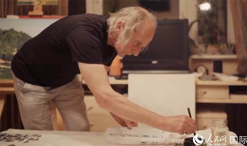 伊戈爾·布爾東諾夫在畫作上題詞。人民網(wǎng)記者 馬天翼攝