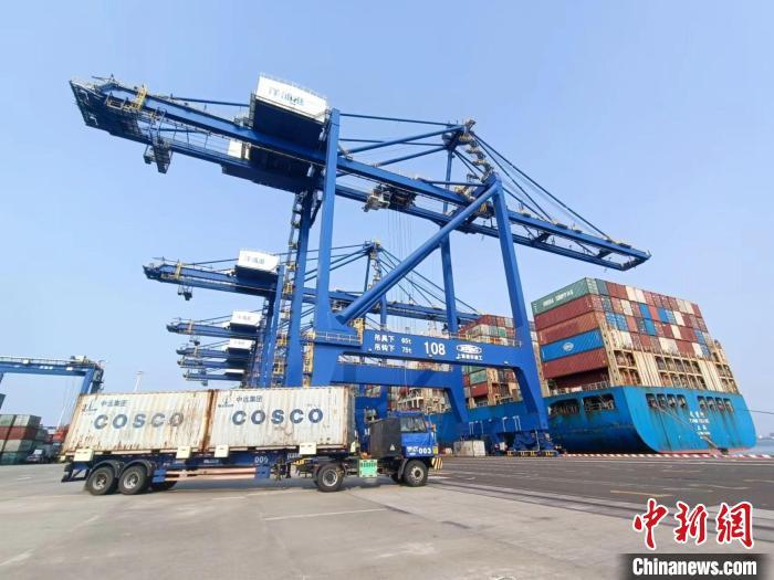 圖為海南洋浦國(guó)際集裝箱碼頭，卡車(chē)將集裝箱從后方堆場(chǎng)運(yùn)往碼頭裝卸區(qū)?！?jiān)潞?攝