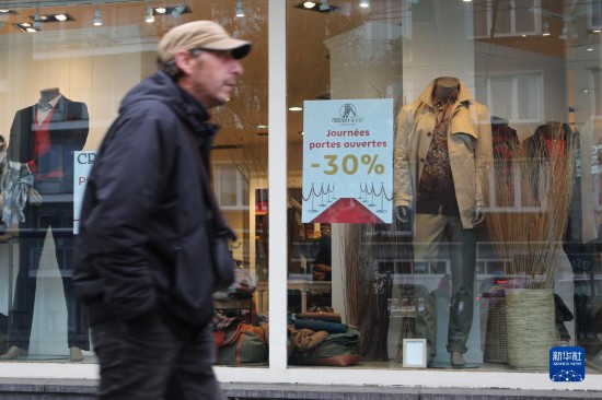   10月31日，一名男子從比利時(shí)布魯塞爾一家貼有打折信息的店鋪前走過(guò)。新華社記者 趙丁喆 攝