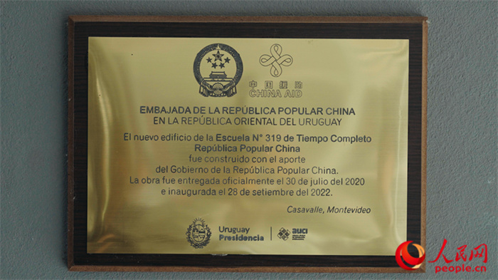 小學墻上懸掛的中國援助標識。人民網(wǎng)記者 張若涵攝
