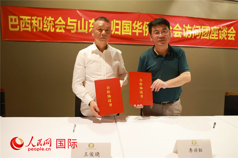 中國僑聯(lián)副主席、山東省僑聯(lián)主席李興鈺（右）與巴西和統(tǒng)會會長王俊曉簽署合作協(xié)議書。人民網(wǎng)記者 陳海琪攝