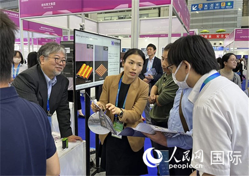 工作人員向參觀者介紹超級(jí)噴墨技術(shù)。（人民網(wǎng)記者 陳思攝）