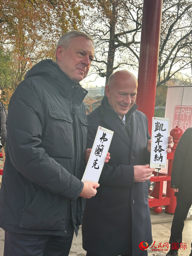 柏林市長韋格納（右）、動物園監(jiān)事會主席布魯克曼（左）手持中國文化中心工作人員現(xiàn)場手書的中文名字。人民網(wǎng)記者 徐馨攝