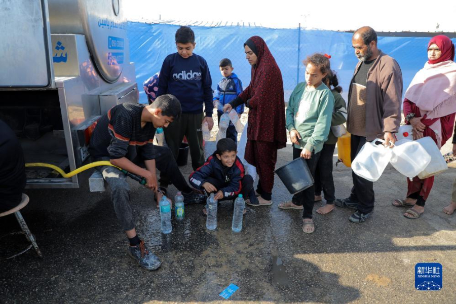 12月8日，在加沙地帶南部城市拉法一處臨時(shí)營(yíng)地內(nèi)，人們排隊(duì)打水。新華社發(fā)（里澤克·阿卜杜勒賈瓦德 攝）