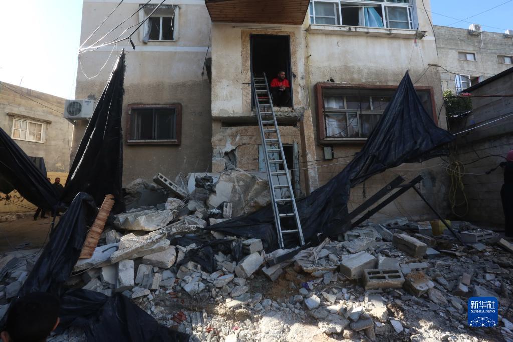 12月17日，在約旦河西岸城市圖勒凱爾姆附近的一處難民營，人們查看在沖突中損毀的房屋。新華社發(fā)（尼達爾·艾仕塔耶?dāng)z）