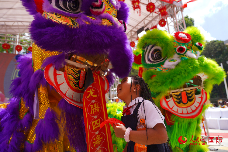 小朋友與舞獅表演者互動(dòng)。人民網(wǎng)記者 黃煒鑫攝