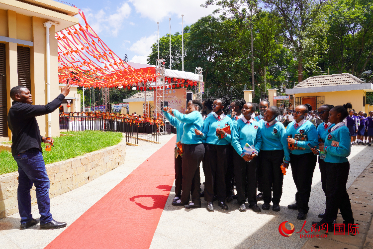 一名老師在給學(xué)生拍照留念。人民網(wǎng)記者 黃煒鑫攝