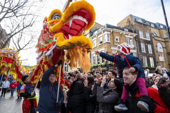 2月11日，人們?cè)谟鴤惗氐男麓貉灿位顒?dòng)中觀看舞龍表演。新華社發(fā)（史蒂芬·程攝）