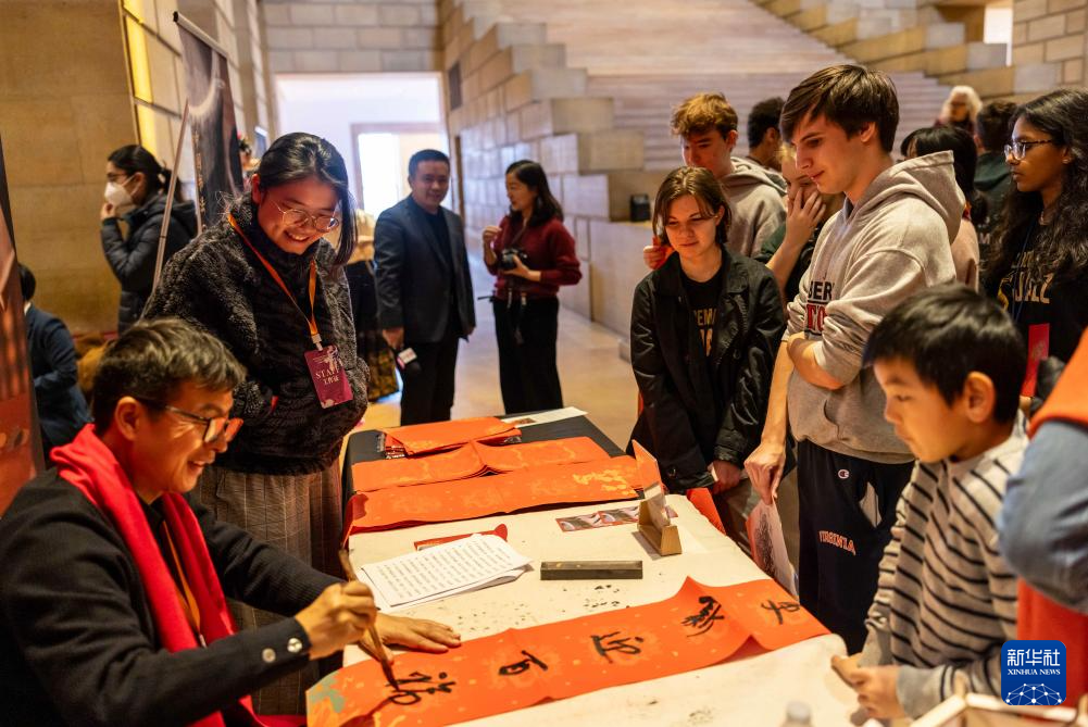 2月11日，書法家在美國(guó)費(fèi)城藝術(shù)博物館舉行的龍年迎新春活動(dòng)上為參觀者書寫對(duì)聯(lián)。新華社發(fā)（周煥新攝）