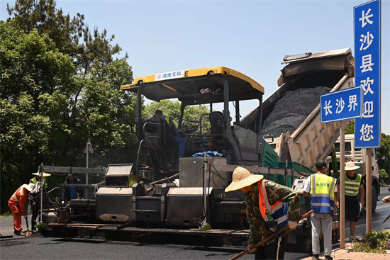 工人正在進(jìn)行“極薄磨耗層”路面的鋪筑。受訪單位供圖