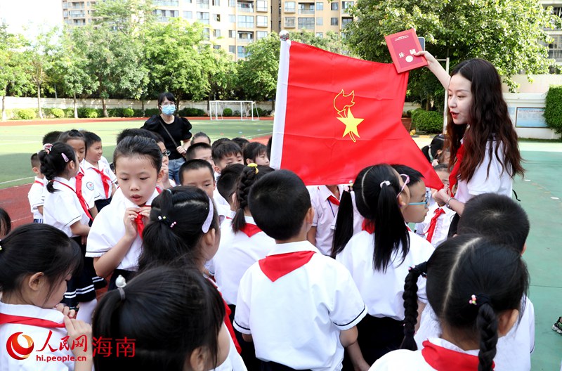 老師向少先隊(duì)員展示隊(duì)旗。人民網(wǎng) 符武平攝