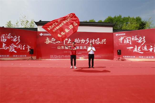 為媒體采風(fēng)團(tuán)授旗。 山東省福彩供圖