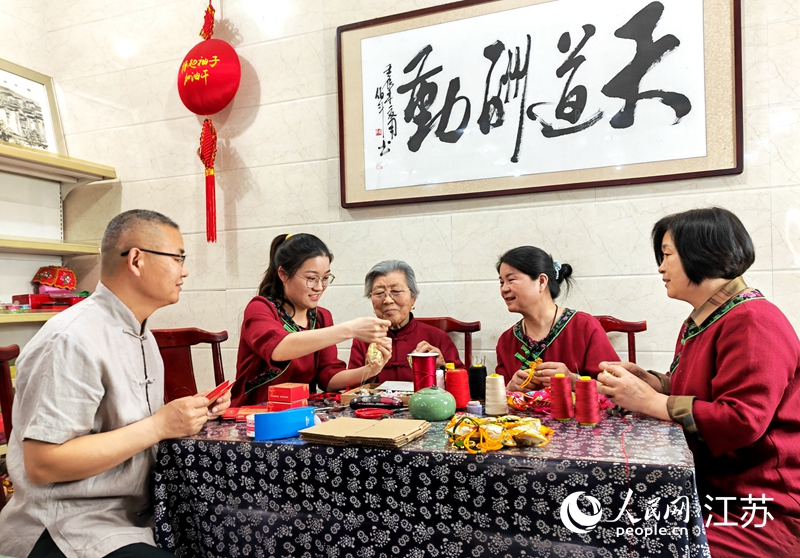 王秀英老人指導(dǎo)孫女制作香包。人民網(wǎng) 閆峰攝