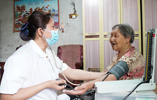 護(hù)理團(tuán)隊(duì)醫(yī)生為老人測量血壓。 陳佳兵攝