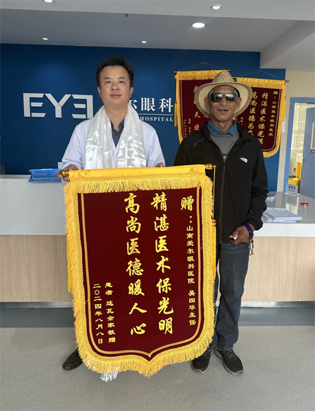 達瓦老人向吳四華（左）贈送錦旗。受訪者供圖