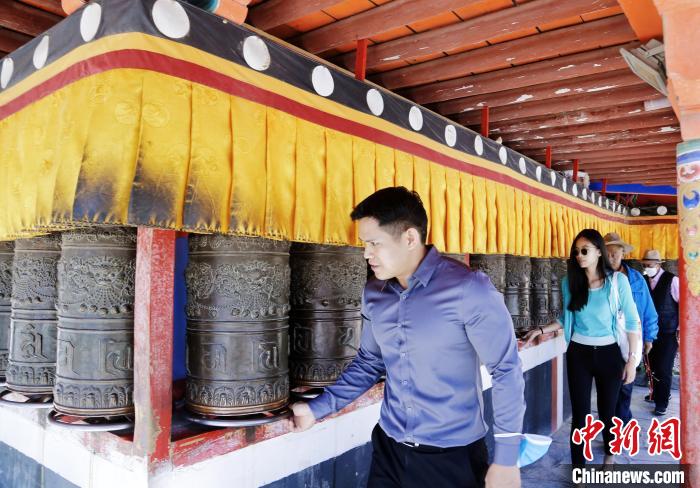 圖為外籍嘉賓體驗(yàn)藏族傳統(tǒng)轉(zhuǎn)經(jīng)筒?！●R銘言 攝