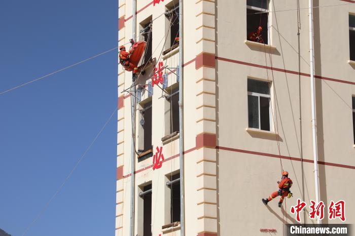 圖為消防指戰(zhàn)員進(jìn)行繩索救援演練。　朱科熹 攝