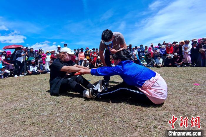 圖為當(dāng)?shù)孛癖娺M(jìn)行蹬棍比賽?！±铍h 攝