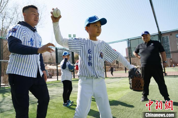 圖為教練指導(dǎo)小棒球手?jǐn)S球技術(shù)?！●R銘言 攝