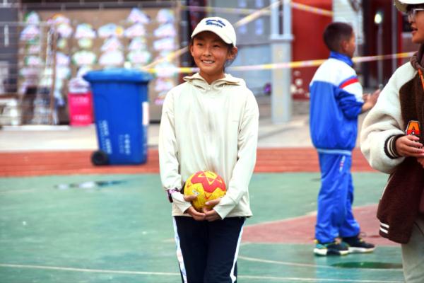 在高原上教孩子們打手球，“慢慢兒來，甭著急！”