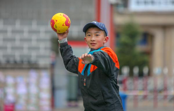 在高原上教孩子們打手球，“慢慢兒來，甭著急！”