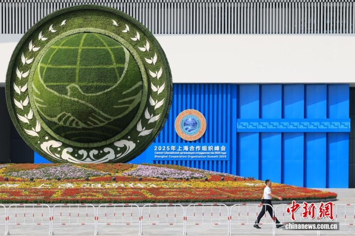 8月31日，天津，一名工作人員從2025年上海合作組織峰會(huì)主會(huì)場(chǎng)外的景觀花壇旁經(jīng)過。當(dāng)日，2025年上海合作組織峰會(huì)在天津舉行。<a target='_blank' href='/'><p  align=