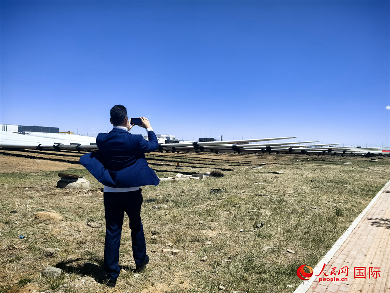 外媒記者拍攝廠房外的風力渦輪發(fā)電機的巨型漿葉。人民網(wǎng) 楊春燕攝