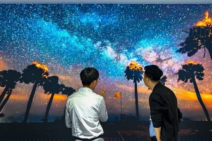 長(zhǎng)春光博會(huì)希達(dá)電子展區(qū)，一位工作人員正在給一位觀眾講解。（長(zhǎng)春新區(qū)供圖）