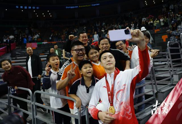 11月12日，十五運(yùn)會(huì)男籃成年組決賽，廣東隊(duì)獲得冠軍后，胡明軒與球迷們合影留念。張由瓊 攝