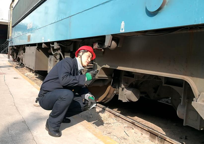 韓文盛全神貫注檢查機(jī)車走行部。