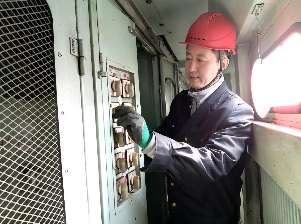 韓文盛認(rèn)真檢查低壓柜。