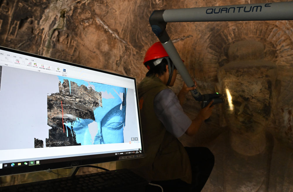 2025年4月9日，武漢大學(xué)文化遺產(chǎn)智能計(jì)算實(shí)驗(yàn)室團(tuán)隊(duì)成員在魏字洞使用關(guān)節(jié)臂掃描儀對(duì)佛像進(jìn)行數(shù)字化掃描。圖片來源新華社