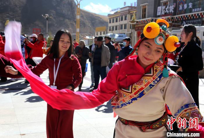 圖為中外記者向當(dāng)?shù)孛癖妼W(xué)習(xí)民族歌舞文化。　張?zhí)砀?攝