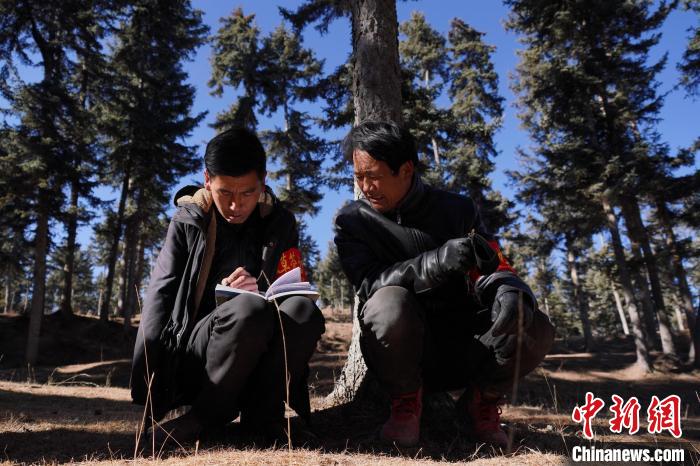 圖為桑杰加(左)和同事記錄巡查結(jié)果。　馬銘言 攝