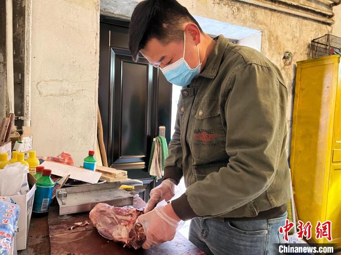 圖為雪豹“奶爸”史壽軍正在準備投喂雪豹的食材?！●R銘言 攝