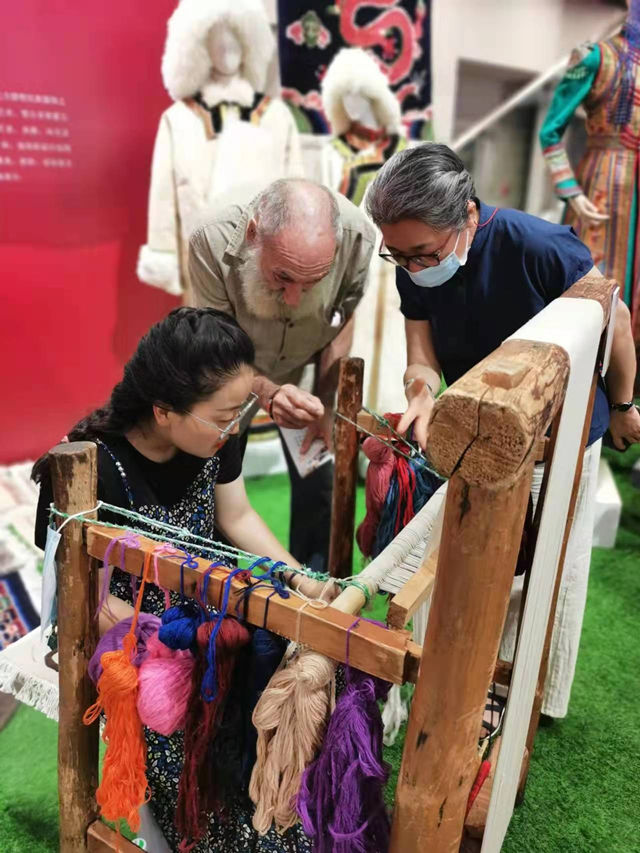 楊永良的學(xué)生在展會(huì)上向客商介紹加牙藏毯編織技藝。受訪者供圖