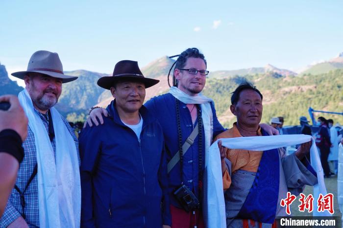 圖為當?shù)孛癖娕c外籍攝影師合影留念。　馬銘言 攝