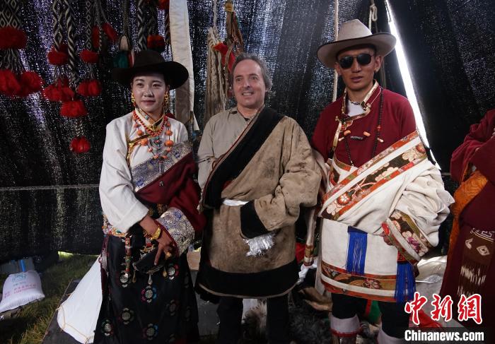 圖為一名外籍?dāng)z影師(中)身穿藏服和藏族民眾合影留念?！●R銘言 攝