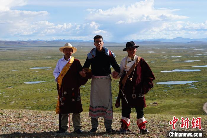 圖為一名留學(xué)生身穿自己國(guó)家的服飾和藏族民眾合影留念?！●R銘言 攝