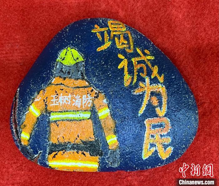 圖為玉樹消防指戰(zhàn)員創(chuàng)作的石頭畫作品《逆行在路上》?！O瑞祥 攝